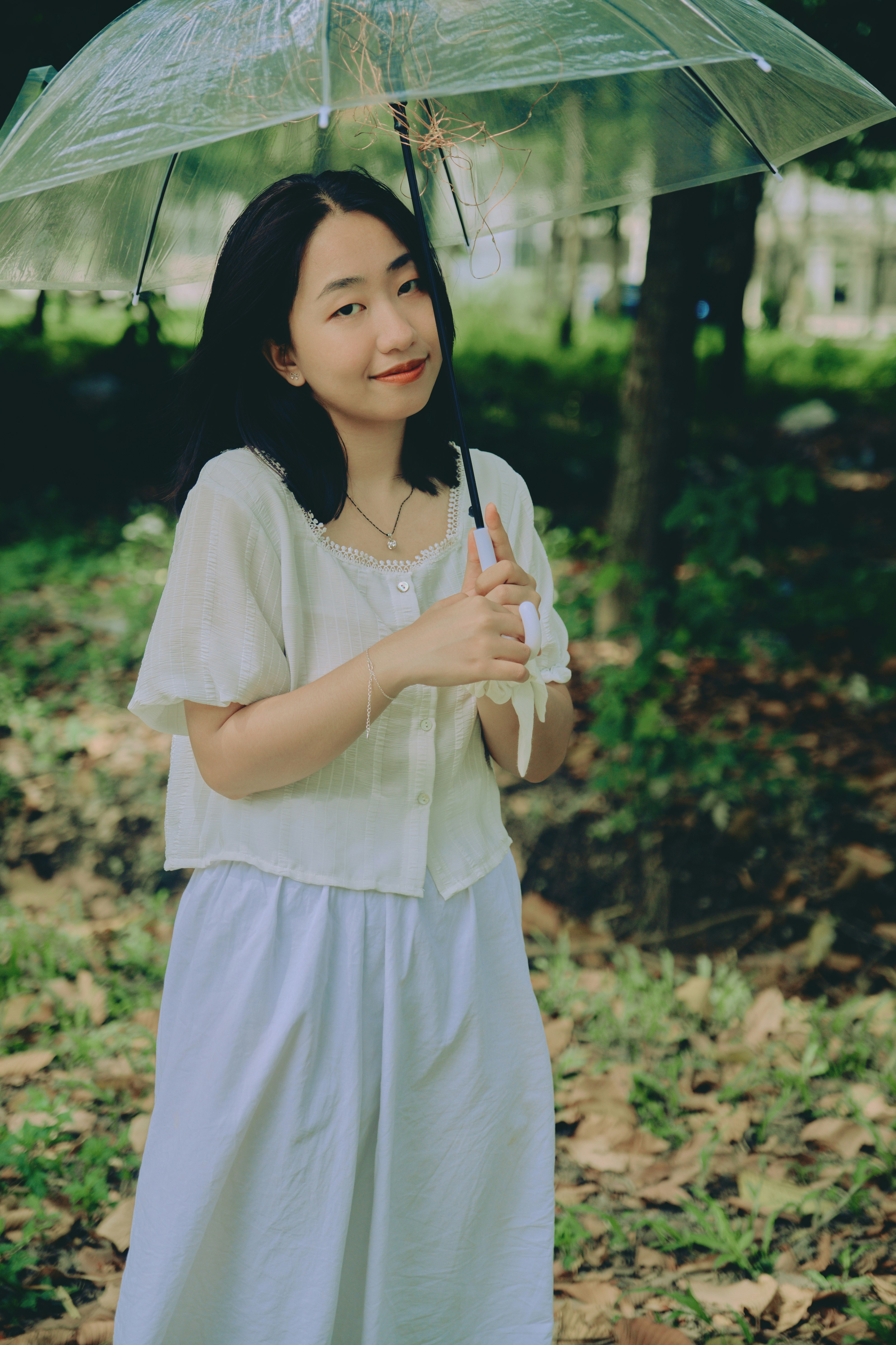 woman in white dress holding umbrella